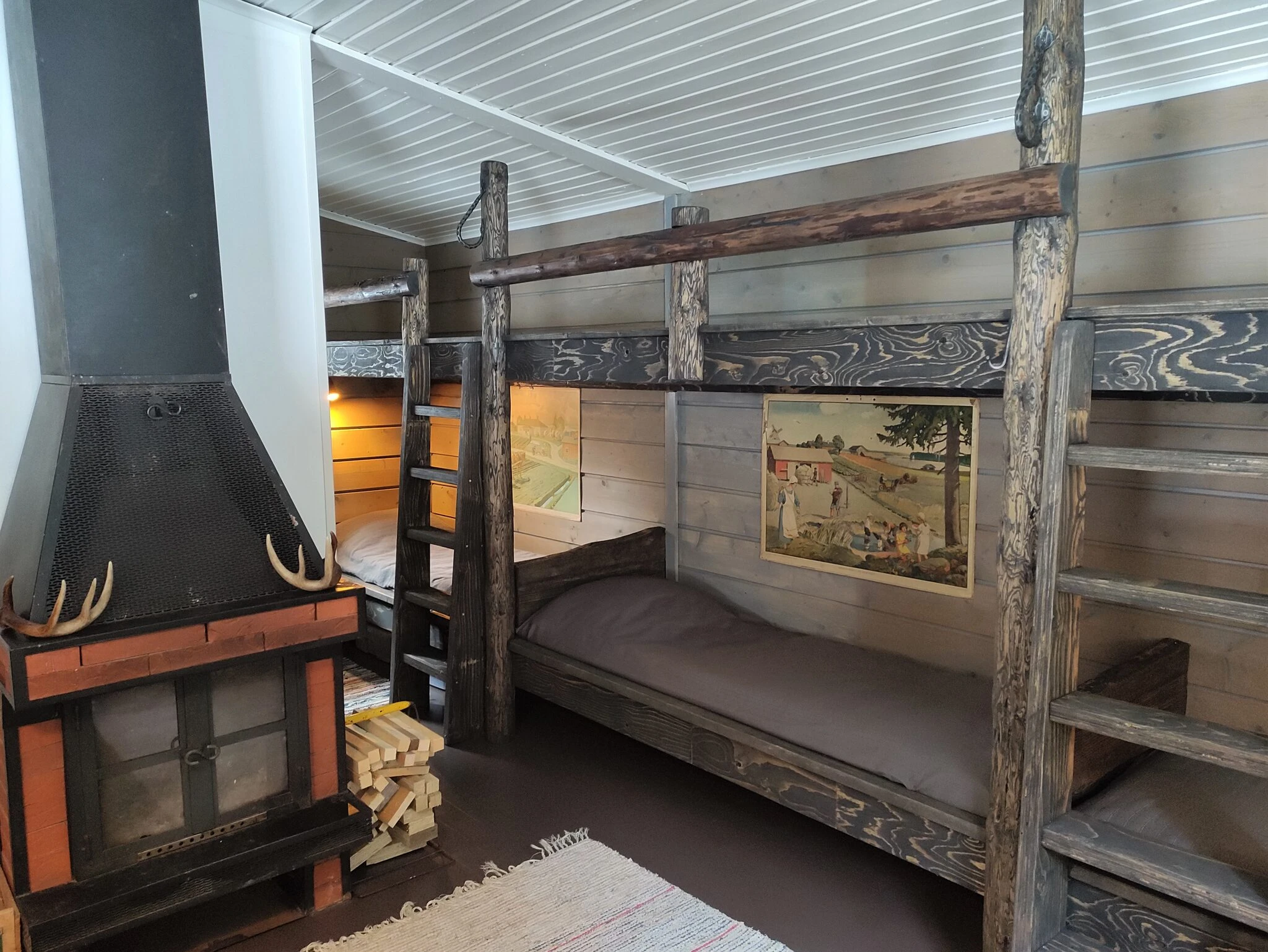 wooden cottage with bunk beds and a fireplace at kettukallion elämystila