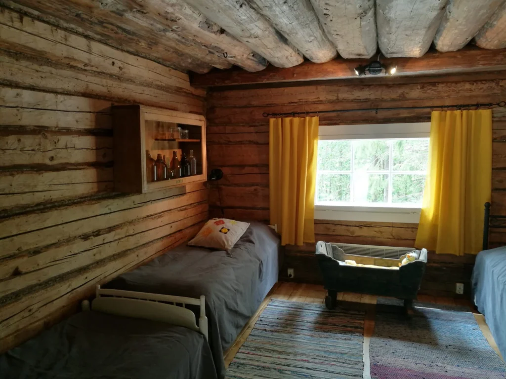 bed and window at kontio luhtiaitta cottage at kettukallio